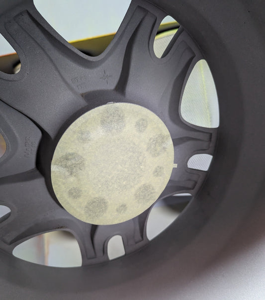 A crepe paper masking disk applied to the center of an alloy wheel