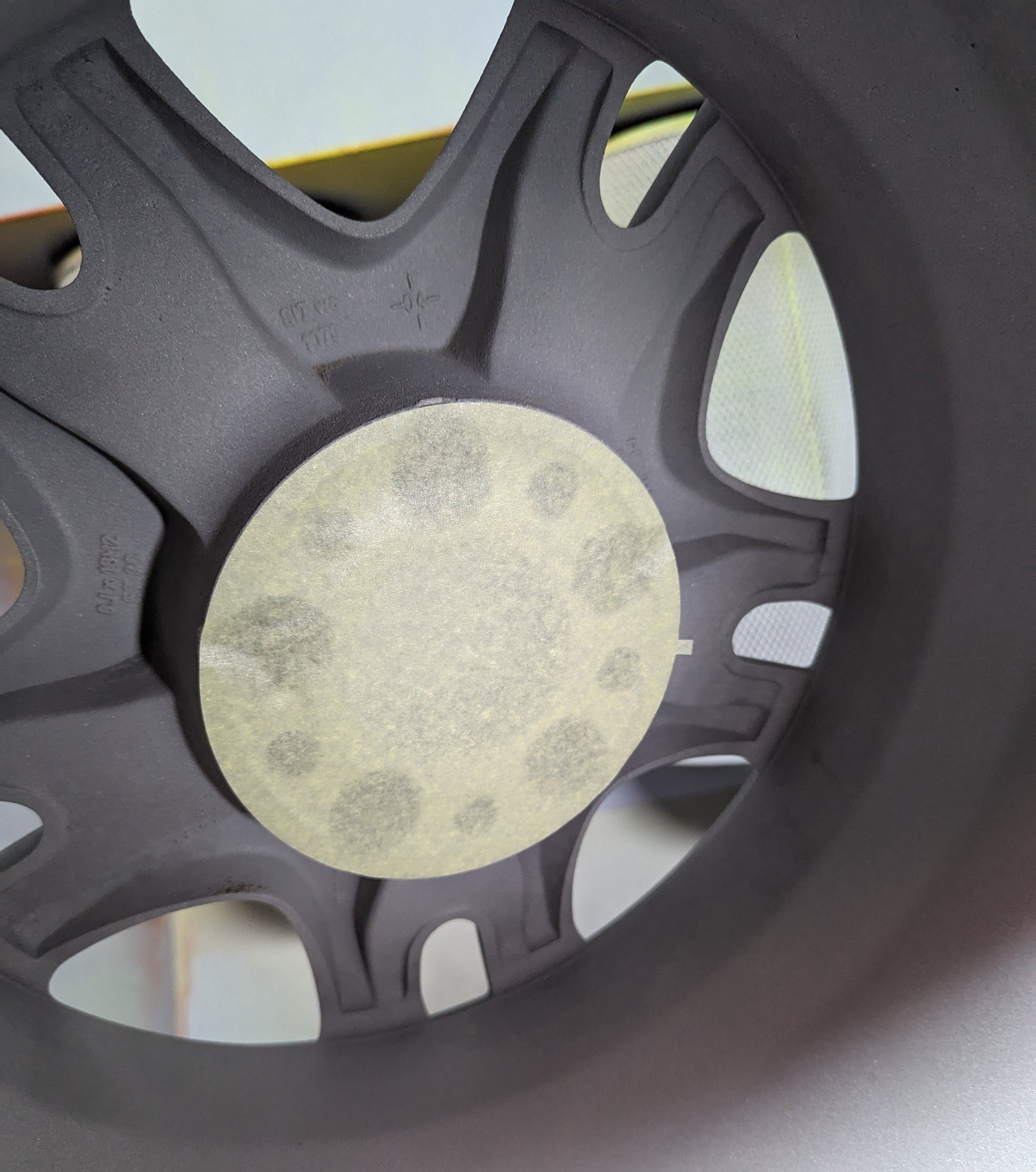 A crepe paper masking disk applied to the center of an alloy wheel